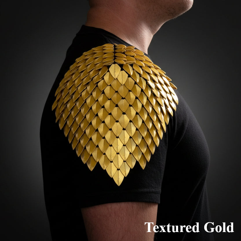 Person wearing a black t-shirt with textured gold shoulder design on a dark background