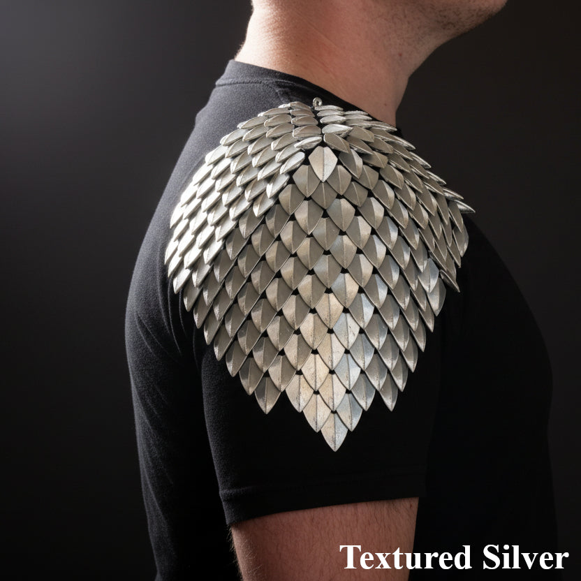Textured silver shoulder piece worn by a person on a black background